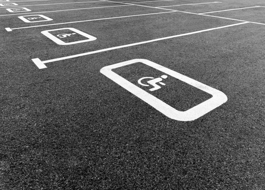 A black and white photo of a parking lot highlighting a disabled parking space.
