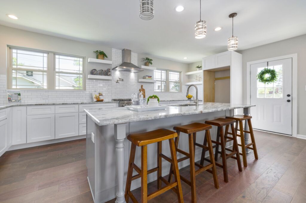 Bright modern kitchen featuring a large island, natural light, and sleek design.