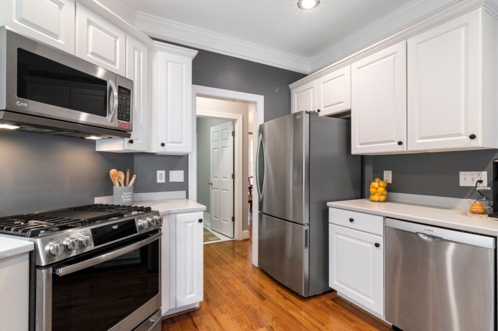 Contemporary kitchen with stainless steel appliances and white cabinets.