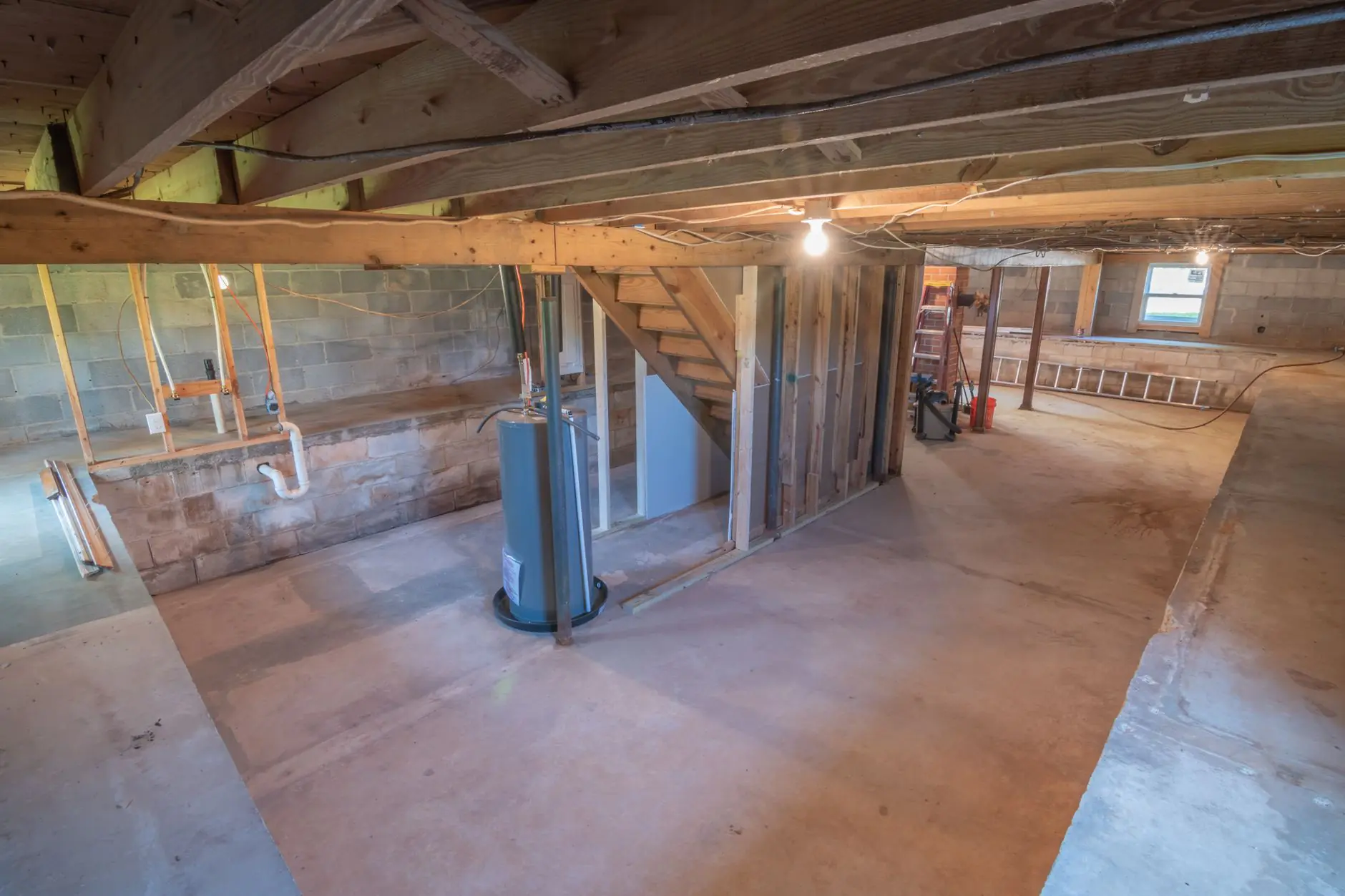 Unfinished basement with exposed beams ready for renovation