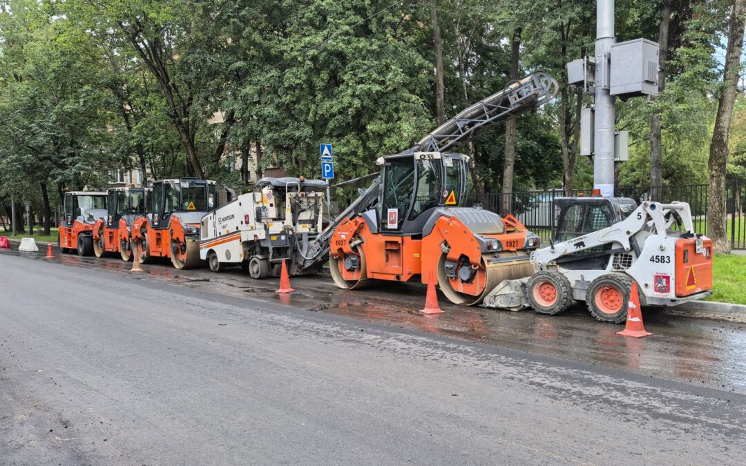 Heavy machinery lined up for road construction in a city.