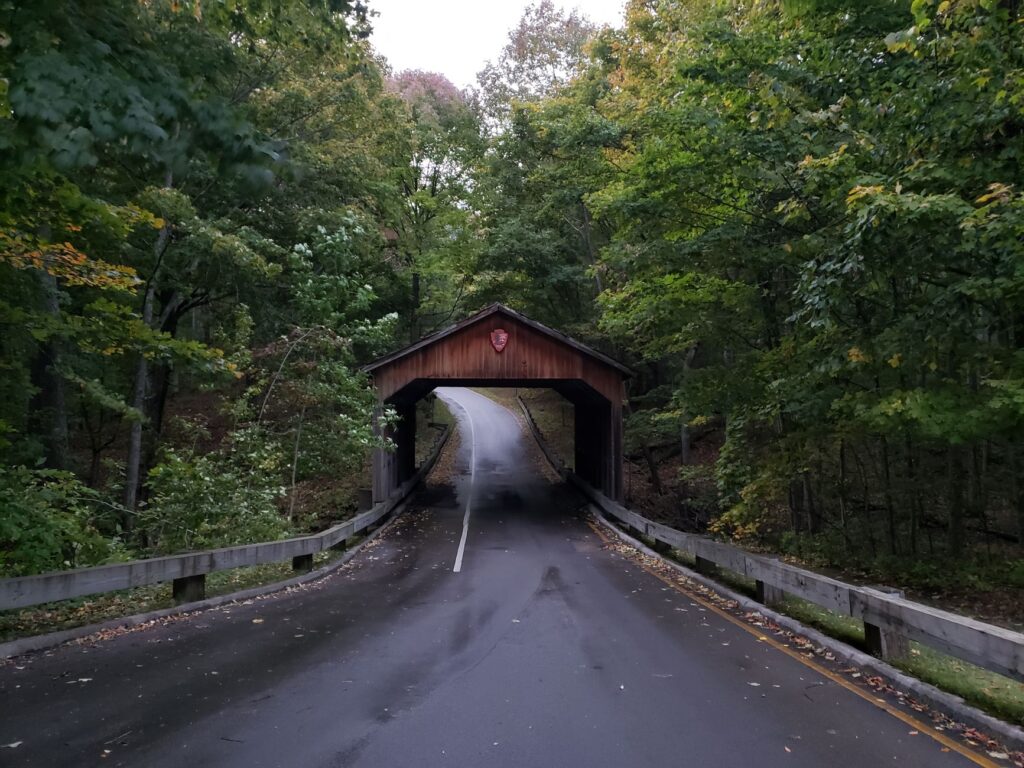 Peaceful covered bridge surrounded by lush fall foliage in Empire, Michigan.