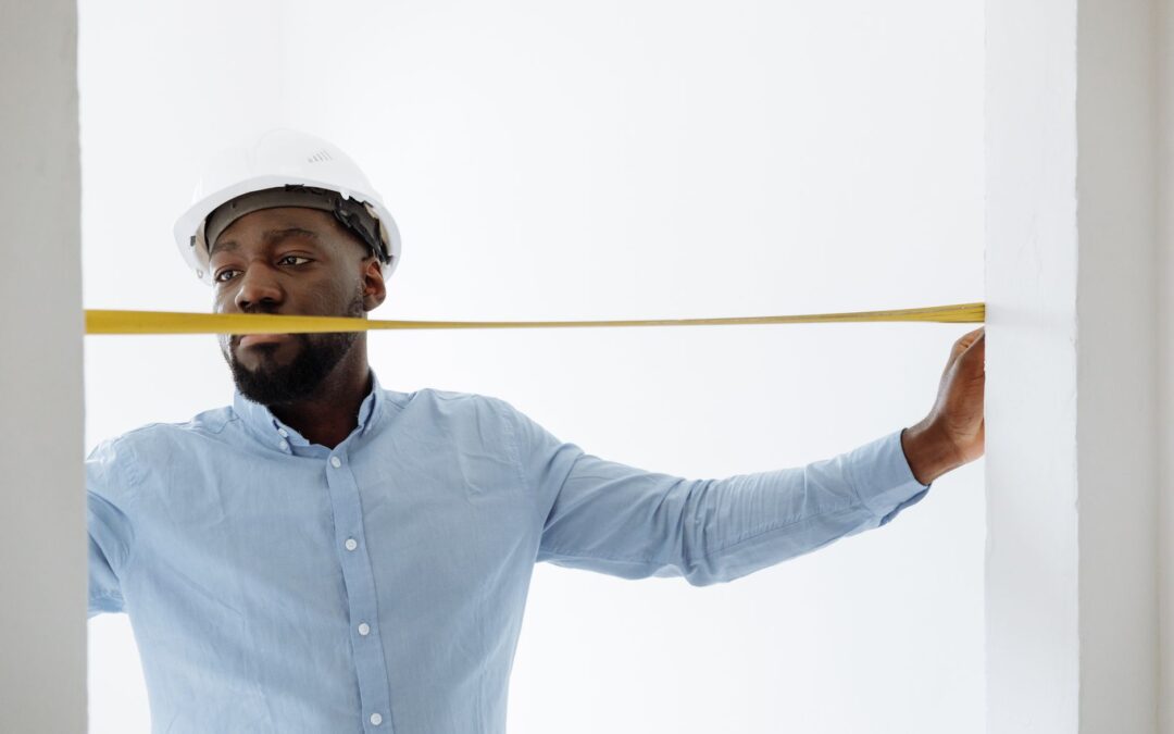 Portrait of a construction worker with a tape measure, working indoors.