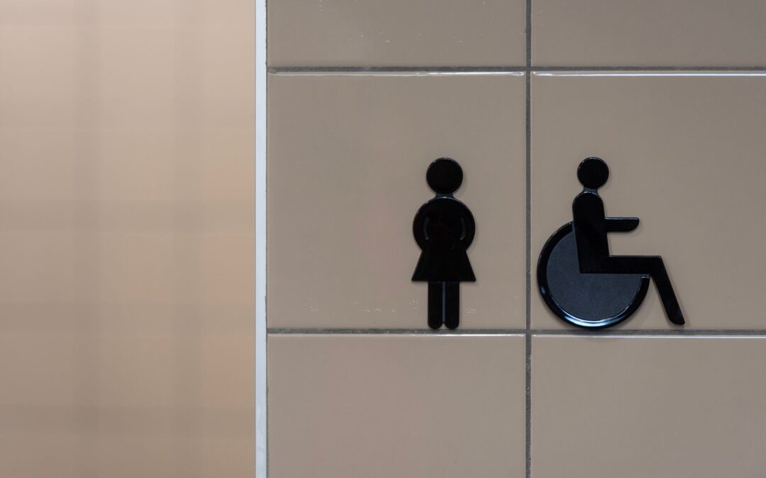 Signage showing symbols for an inclusive restroom with wheelchair accessibility.