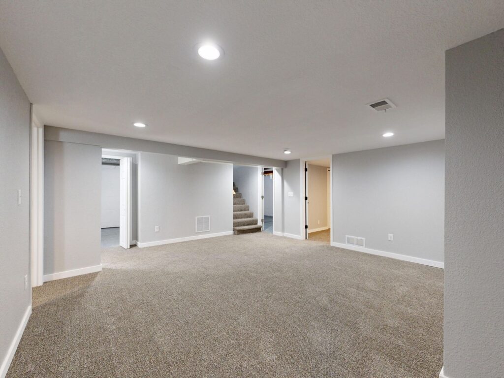 Spacious modern basement with neutral design and carpet flooring, perfect for renovation or real estate listings.