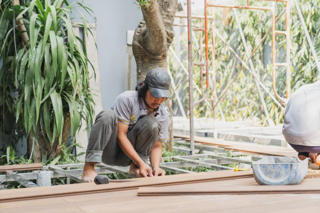 A skilled carpenter working with wooden planks outdoors in Hồ Chí Minh City.
