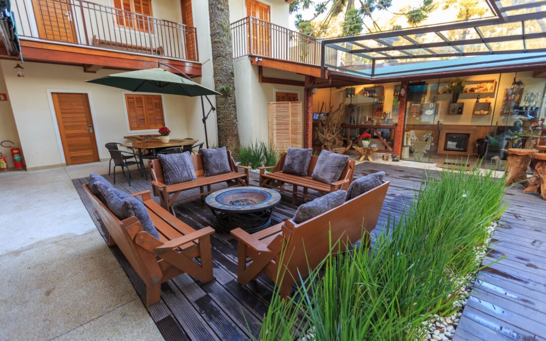 A welcoming outdoor patio with wooden furniture and lush plants in a modern residential courtyard.