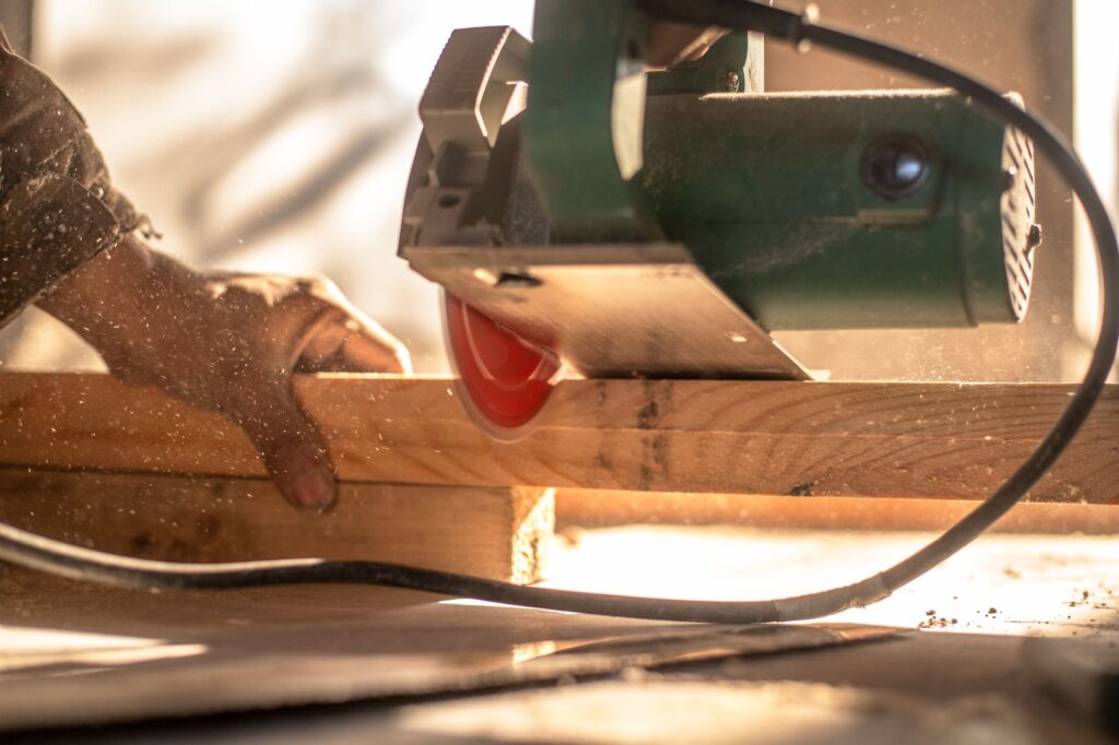 Circular saw cutting a wooden plank with visible dust particles, highlighting craftsmanship.