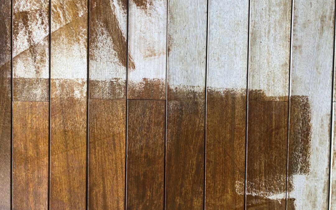 Close-up of a rustic wooden fence with peeling white and brown paint, highlighting texture.