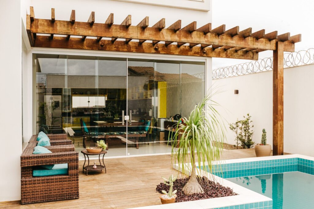 Cozy interior of lounge terrace with swimming pool in modern villa in daytime