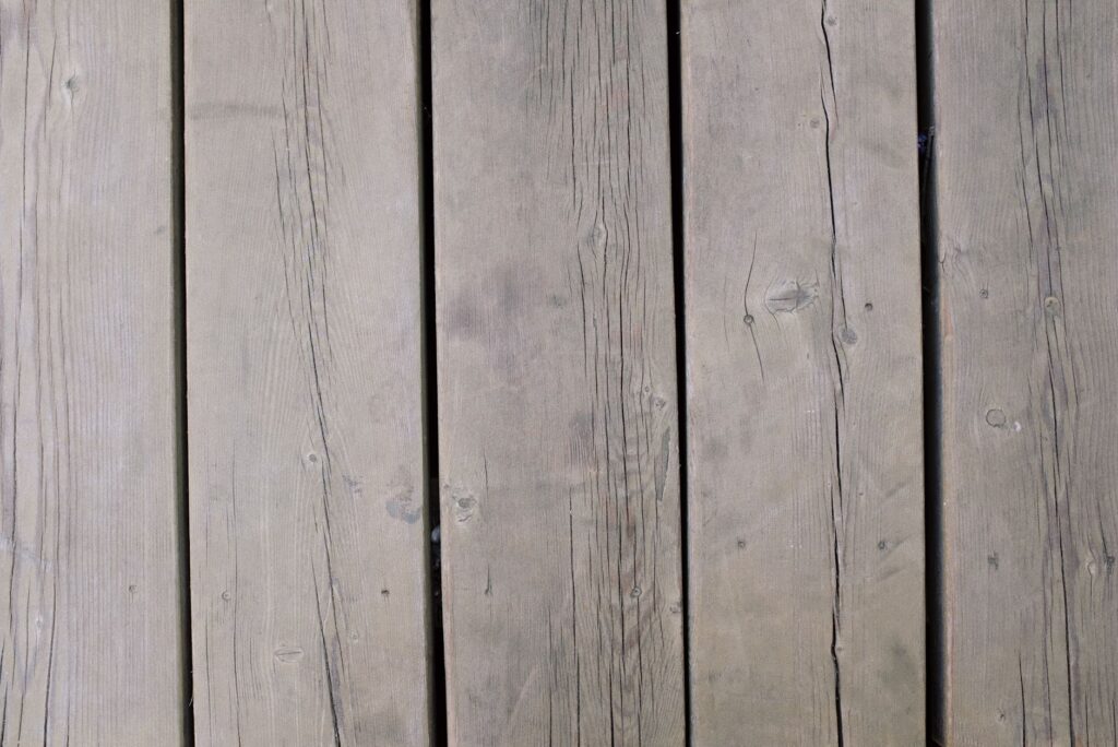 Detailed view of weathered wooden planks, showcasing texture and grain, ideal for backgrounds and design use.