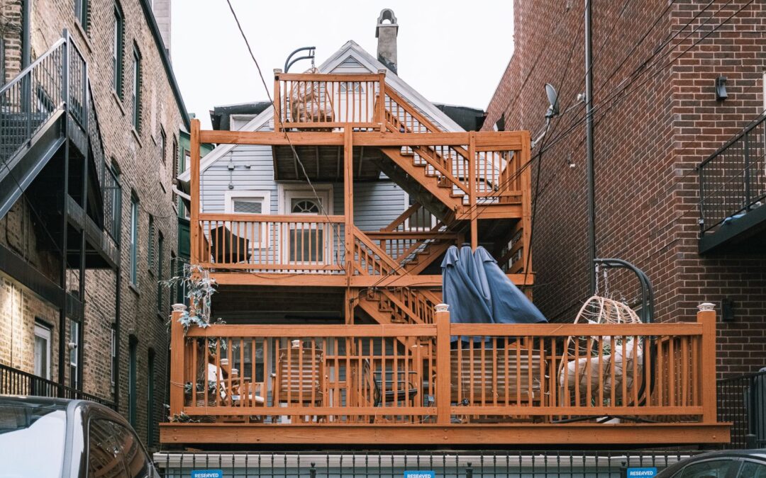 Multi-level wooden deck between urban buildings, showcasing unique architectural design.