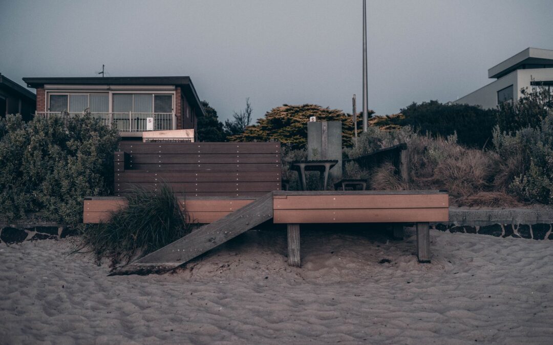 Serene beachfront view featuring sandy shores and cozy wooden decking.