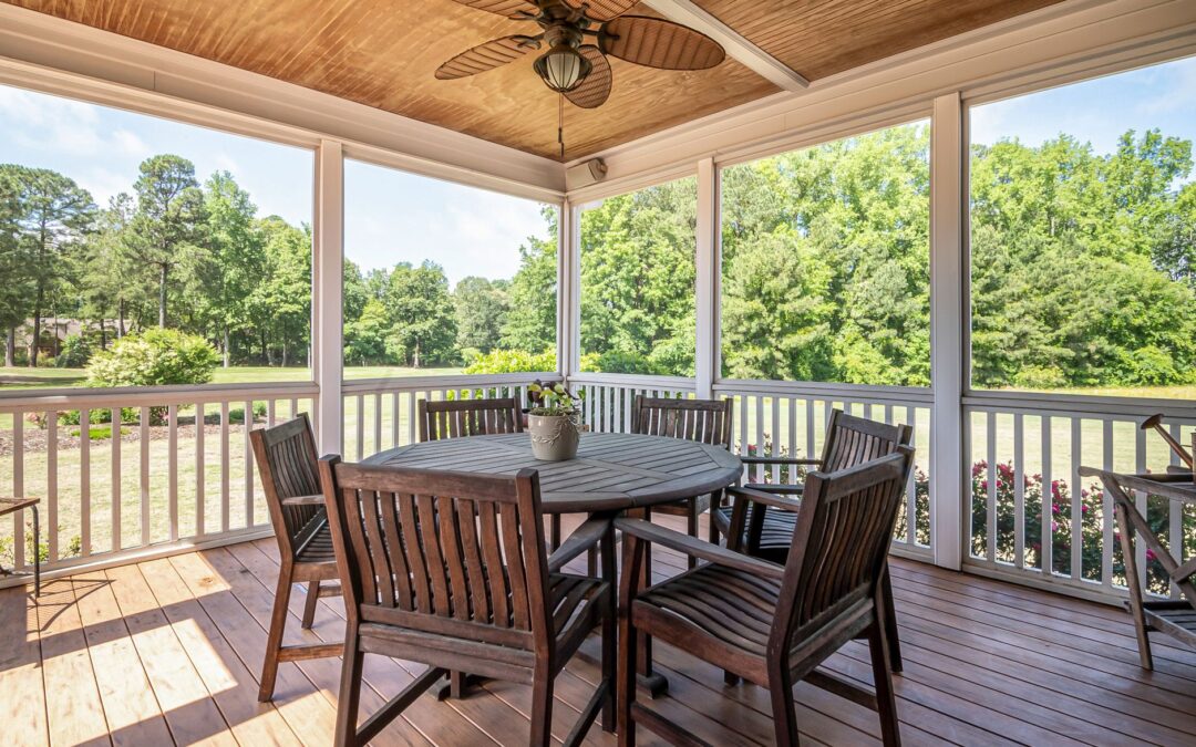 Spacious outdoor patio featuring wooden furniture and scenic garden view, perfect for relaxation.