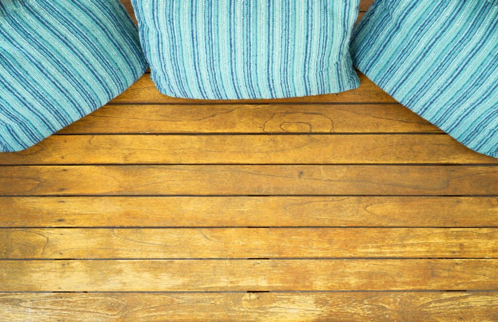 Top view of striped cushions on a wooden floor, creating a cozy home decor setting.