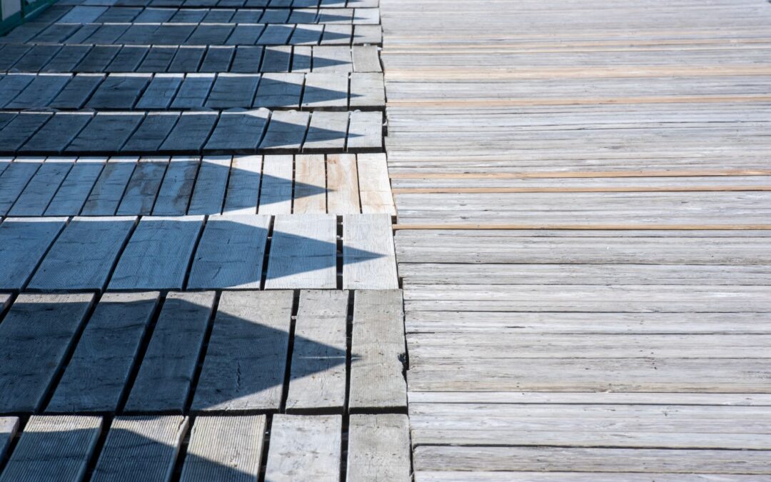 Wooden slats creating geometric shadow patterns on a sunny day.